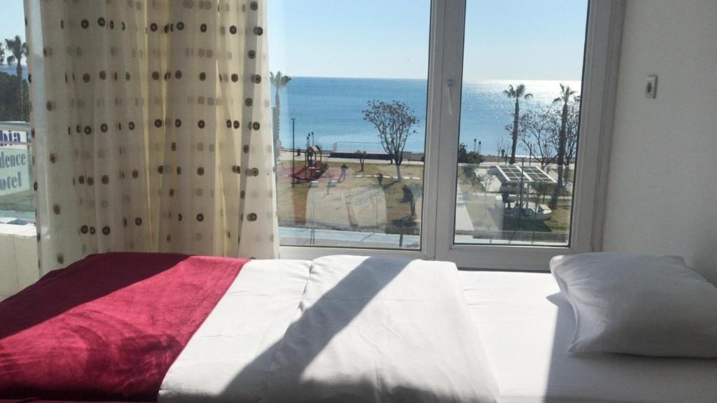 ein Schlafzimmer mit einem Bett und einem großen Fenster in der Unterkunft Olbia Residence Hotel in Antalya
