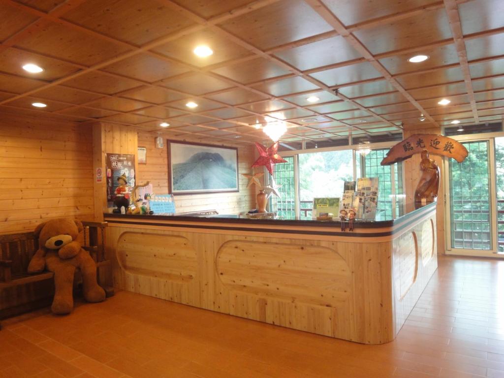 a teddy bear sitting at a bar in a room at Kingtaiwan Hotel in Lugu Lake