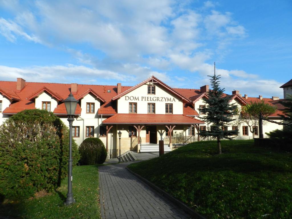 un grand bâtiment blanc avec un toit rouge dans l'établissement Dom Pielgrzyma, à Kalwaria Zebrzydowska