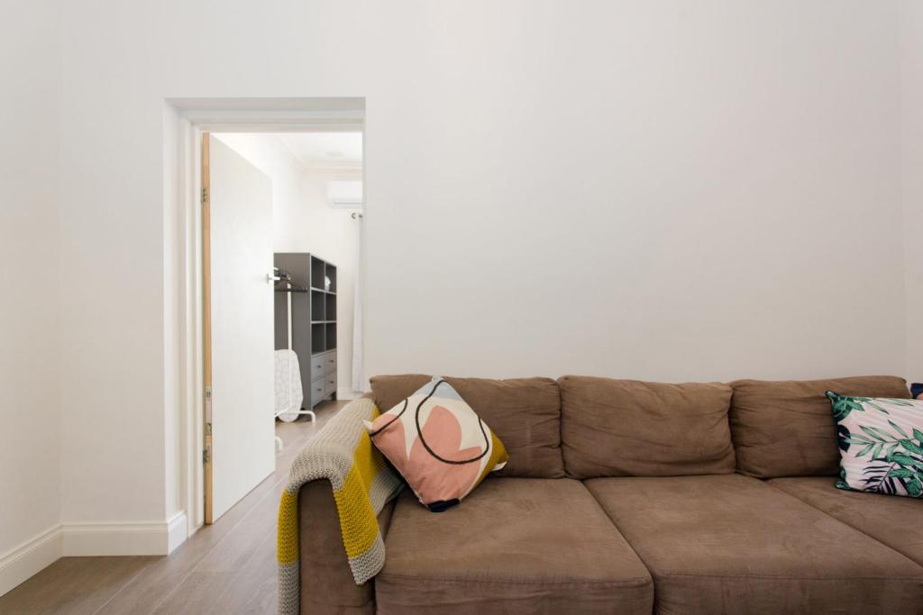 un soggiorno con un divano marrone e una TV di Quokka at White Gum Lodge a Fremantle