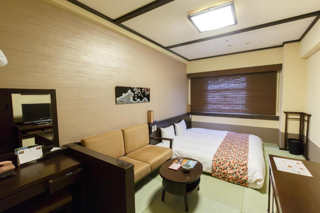 a hotel room with a bed and a desk at Takayama Ouan in Takayama