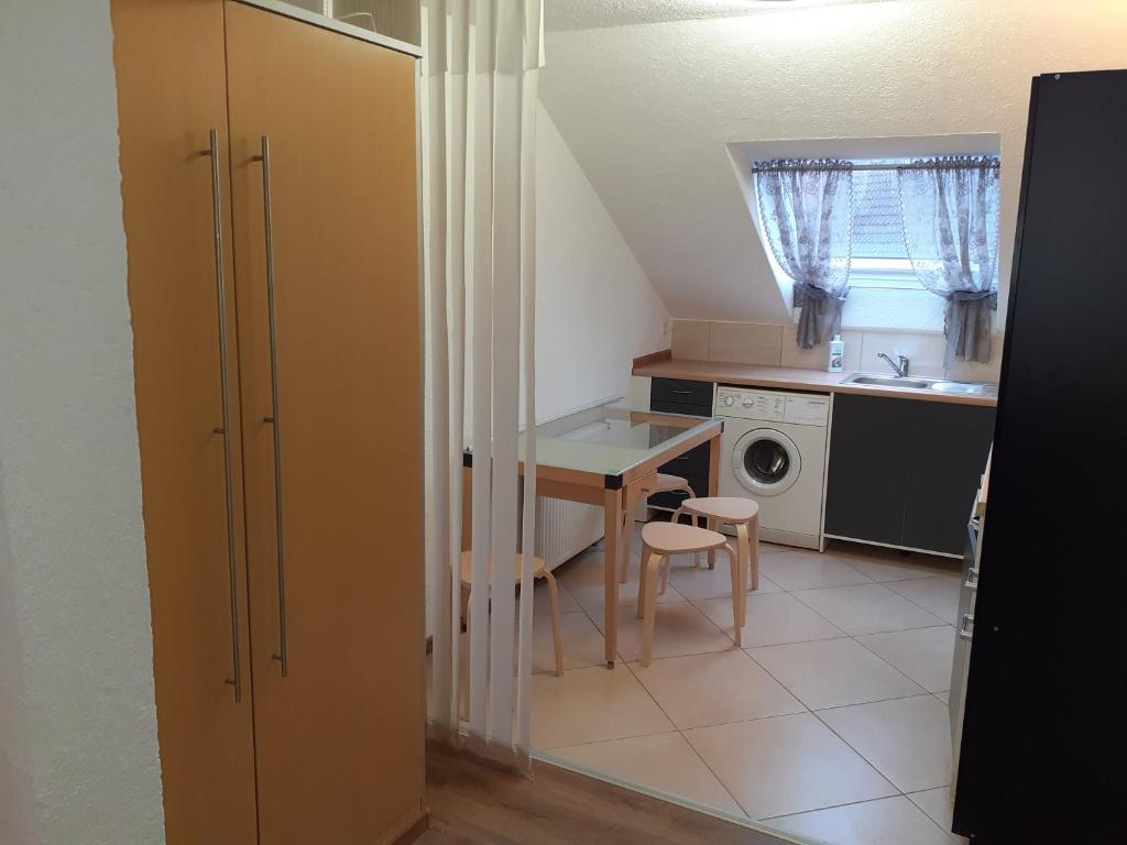 uma pequena cozinha com uma mesa e um lavatório em Apartment City Metzingen em Reutlingen