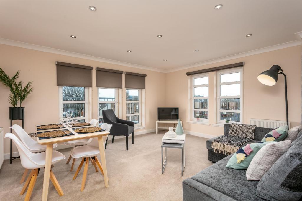 a living room with a couch and a table at The Lucas - Donnini Apartments in Ayr