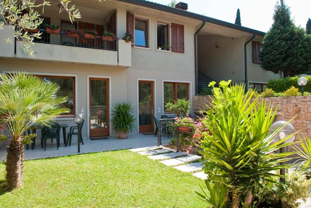 a house with a patio with a table and chairs at Casa Facchinetti Blue apartment in Malcesine