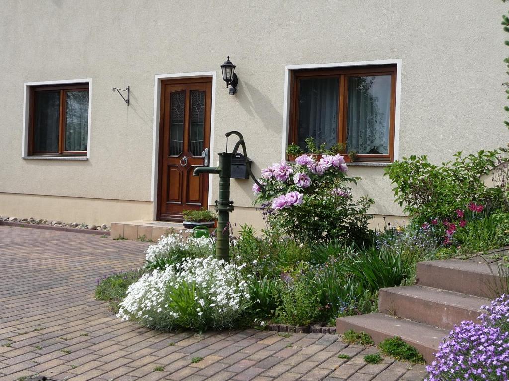 a house with flowers in front of a door at Ferienwohnung Wilsdruff - Kaufbach in Wilsdruff