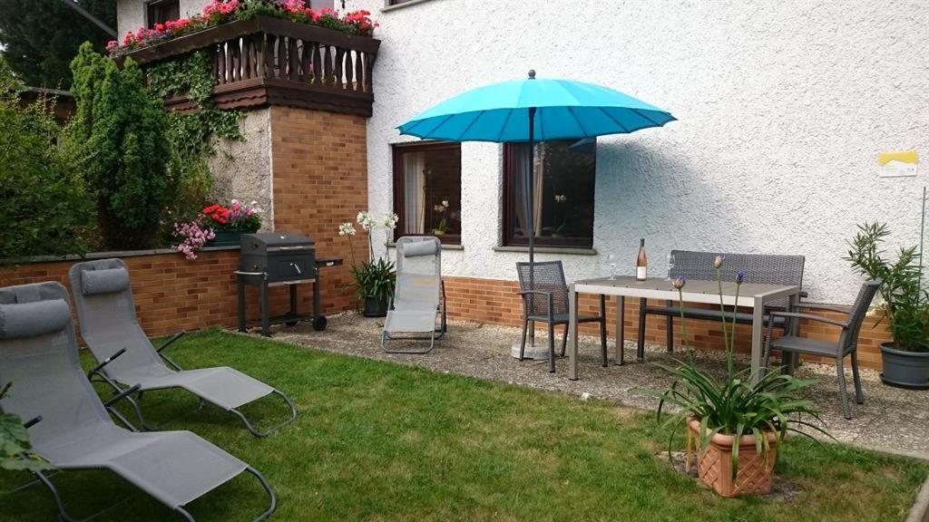 a patio with a table and chairs and an umbrella at Ferienwohnung Maifeld in Wierschem