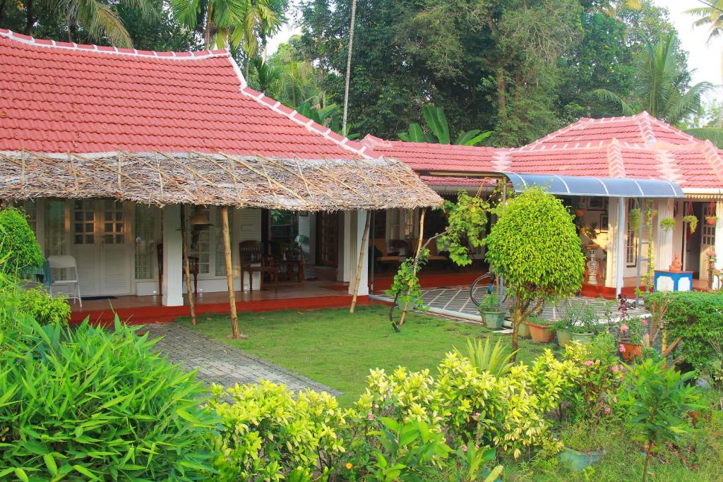 a house with a red roof and a garden at Orchid Villa homestay in Vaikom