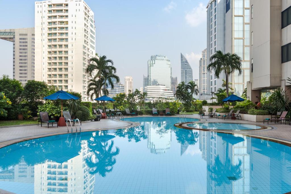 a large swimming pool in a city with tall buildings at Rembrandt Sukhumvit - SHA Extra Plus in Bangkok