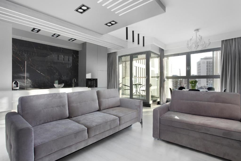 ein Wohnzimmer mit 2 Sofas und einem Tisch in der Unterkunft Elite Apartments Granaria Luxury in Danzig