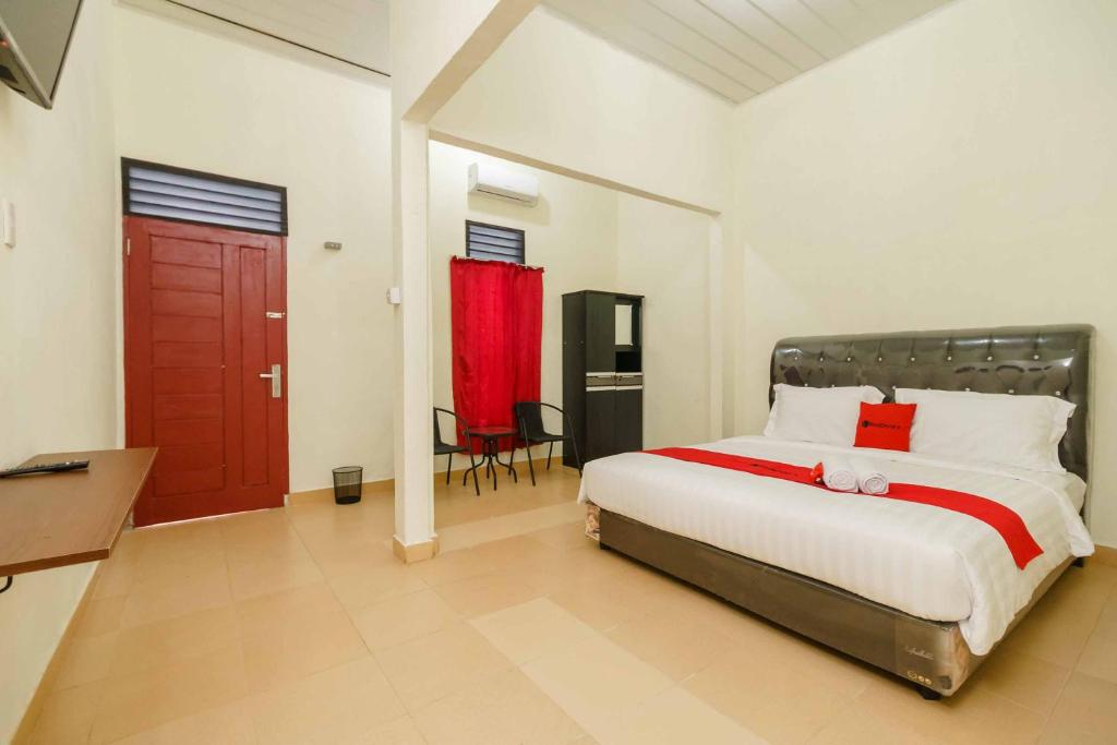 ein Schlafzimmer mit einem großen Bett und einer roten Tür in der Unterkunft RedDoorz Plus @ Setiabudi Medan 4 in Sunggal