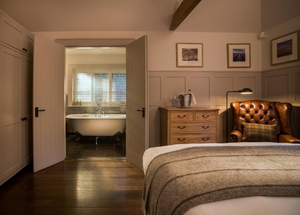 a bedroom with a bed and a tub and a sink at Hurley House Hotel in Hurley