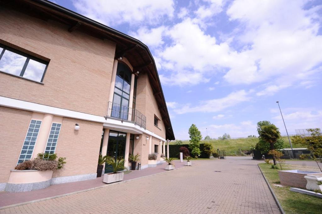 a building with a brick sidewalk next to a building at Hotel - Motel Flower in Gropello Cairoli