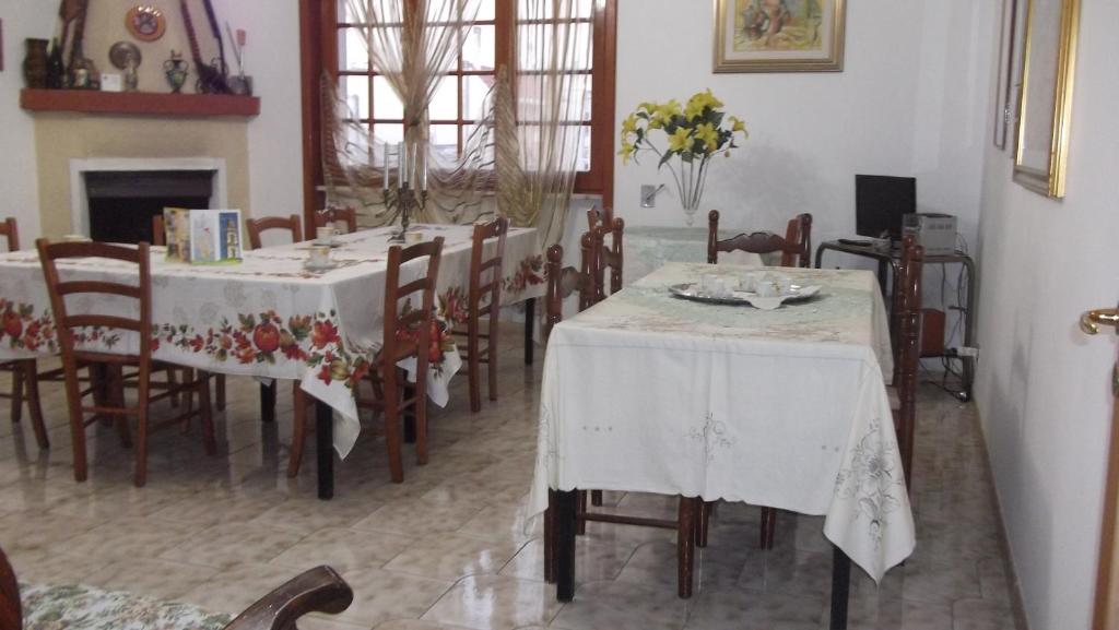 a dining room with two tables and chairs and a fireplace at Il campanile in Soleto