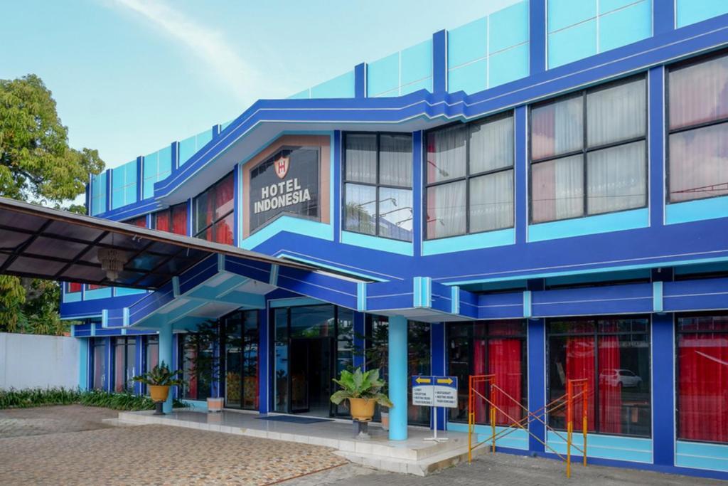 ein blaues Gebäude mit roten Türen in der Unterkunft RedDoorz Plus Syariah near Stasiun Pekalongan 2 in Pekalongan