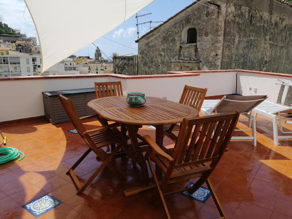 a wooden table and chairs on a balcony at Donna Rosalia in Amalfi