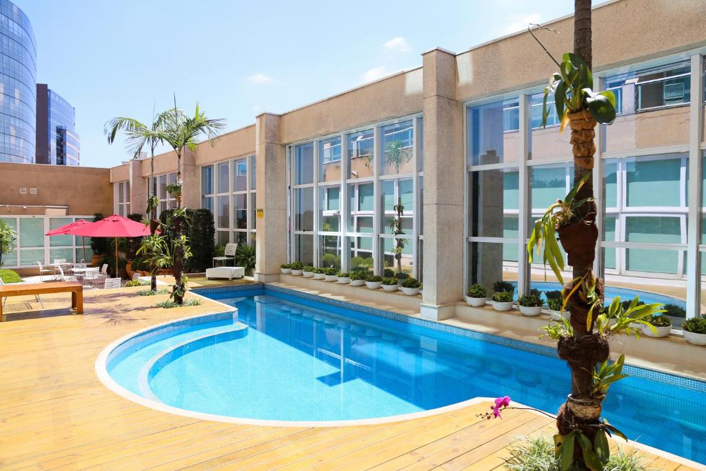 a swimming pool in front of a building at Vitória Hotel Concept Campinas in Campinas