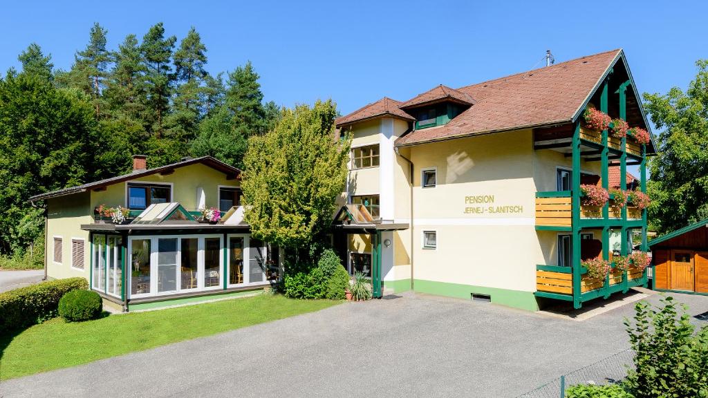 uma grande casa branca com acabamento verde em Frühstückspension Slanitsch em Sankt Kanzian