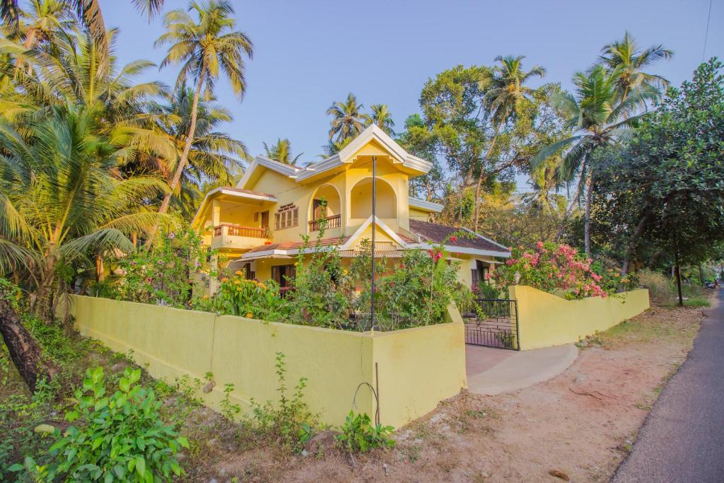 a yellow house on the side of a road at Belleville - A Peaceful Holiday Home in Madgaon