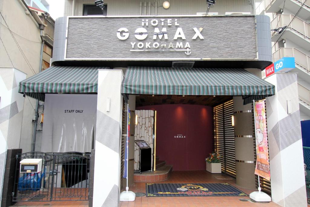 un front de magasin avec un auvent vert sur un bâtiment dans l'établissement Gomax (Adult Only), à Yokohama