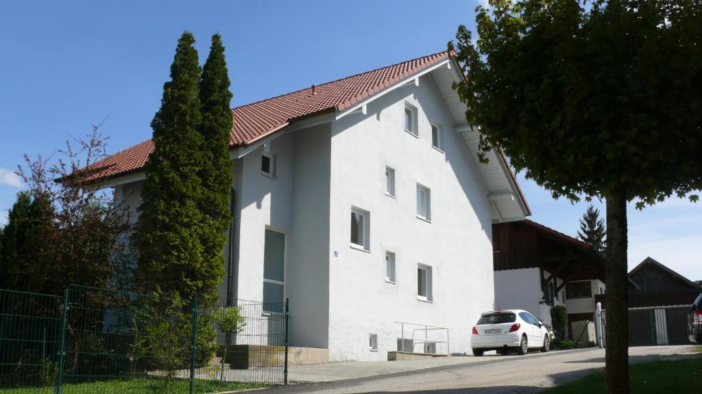 a white building with a car parked in front of it at Gästehäuser Arnstorf in Arnstorf