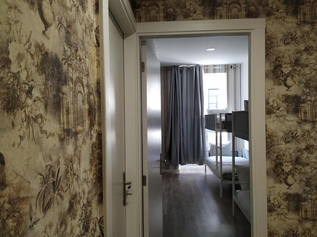 un couloir avec une porte menant à une chambre dans l'établissement Majestic Hostel Porto, à Porto