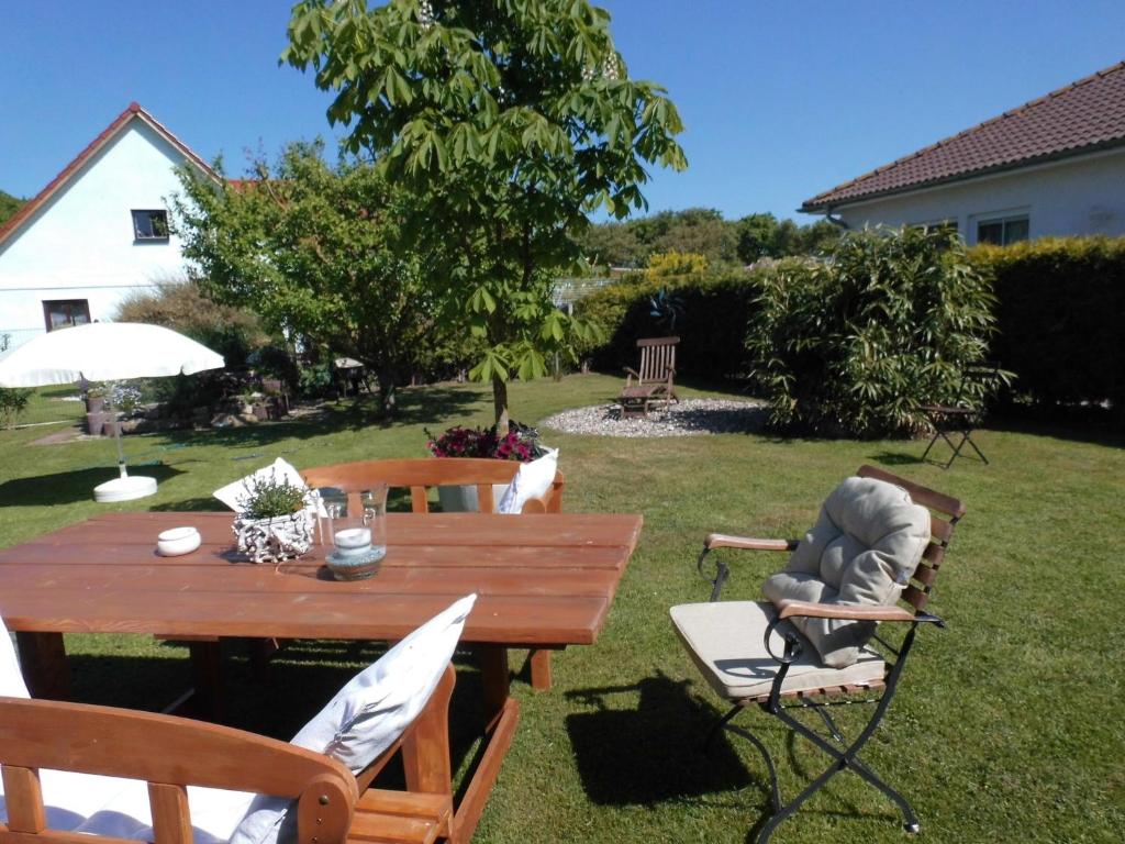 a wooden table and chairs in a yard at Apartment in Pepelow with Roofed Terrace, Garden, Barbecue in Pepelow