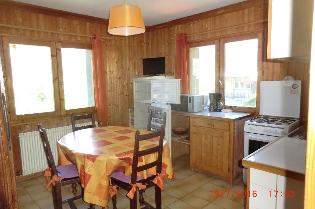 cocina con mesa y cocina con fogones y nevera en Les Passereaux 2, en Saint-Gervais-les-Bains