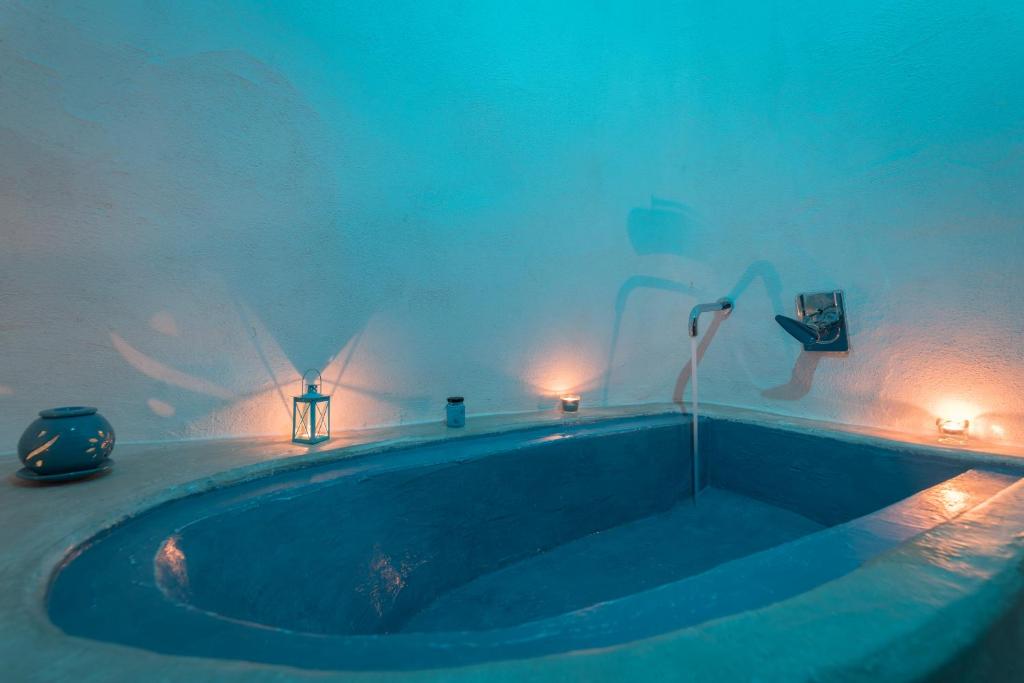 a bath tub in a room with lights on the wall at Azzurro Come Te - Ostuni in Ostuni