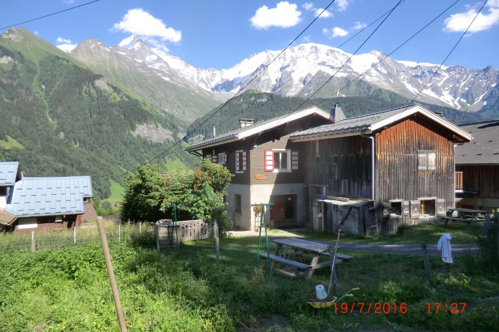 un par de edificios con montañas en el fondo en Les Passereaux 2, en Saint-Gervais-les-Bains