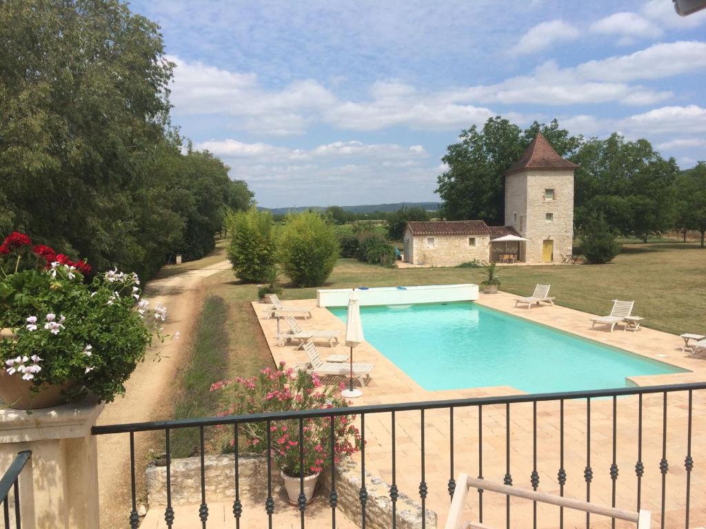 uma vista para uma piscina a partir de uma varanda em Le Manoir du Port em Grézels