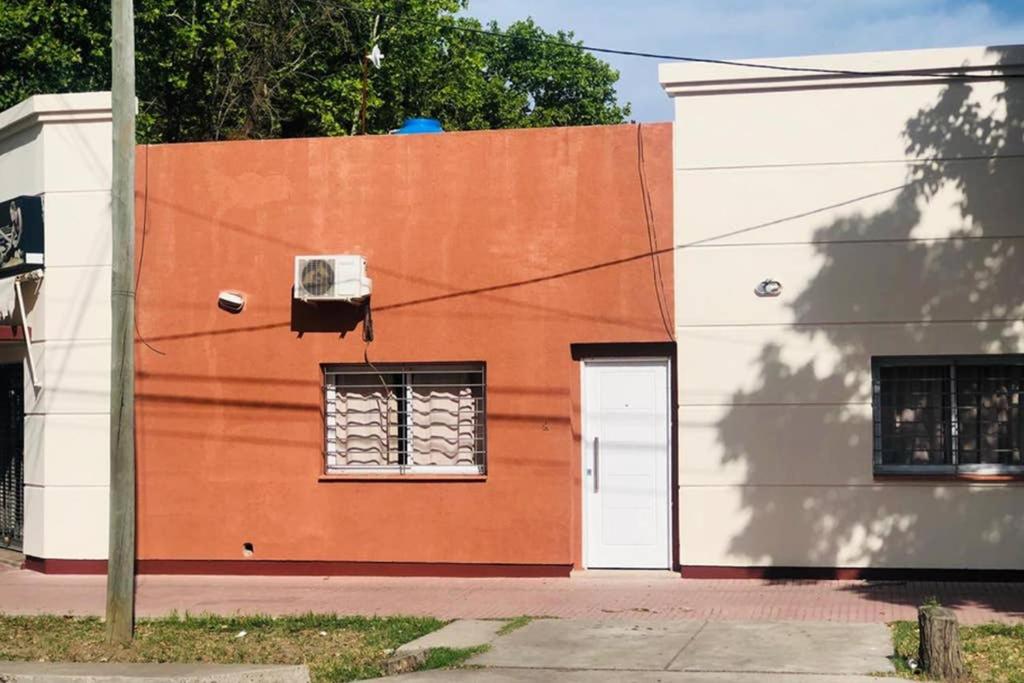 un edificio naranja y blanco con una puerta blanca en Departamento en pleno centro, a metros de todo ! en San Rafael