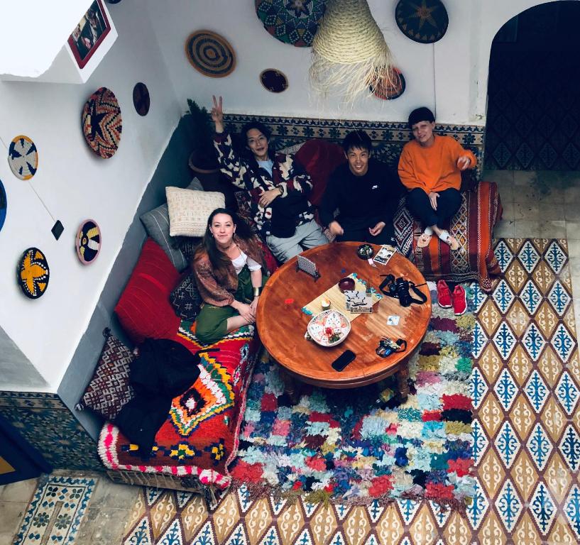 Un groupe de personnes assises autour d'une table dans une pièce dans l'établissement berber hostel, à Essaouira