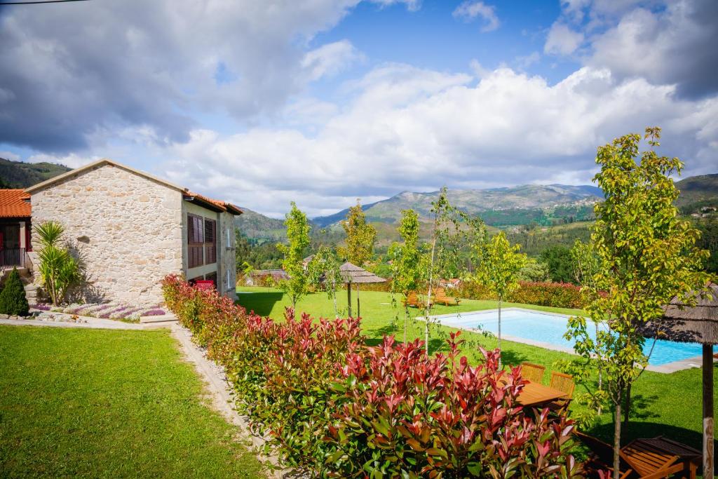 a garden with a house and a swimming pool at Casas de São Martinho in Arcos de Valdevez