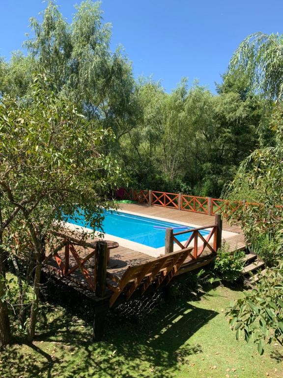 una piscina en un patio con una valla y árboles en Cabaña Magnolia en Marea Delta del Tigre en Tigre
