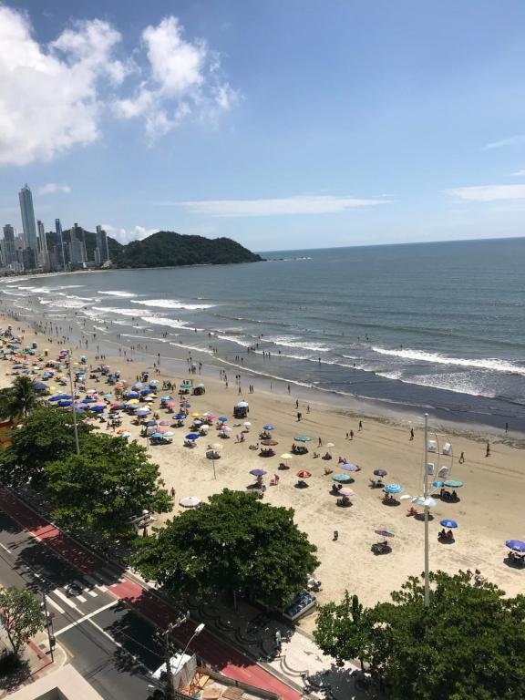 una playa con muchas sombrillas y gente en ella en Apartamento Frente Mar, en Balneário Camboriú