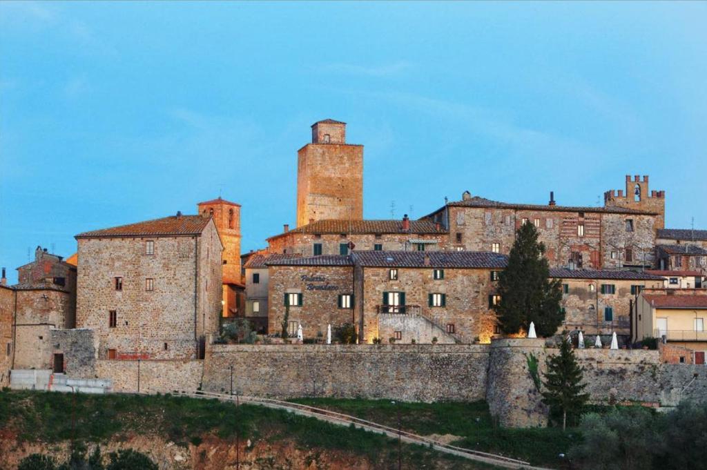 a group of old buildings with towers on a hill at Palazzo Brandano in Petroio