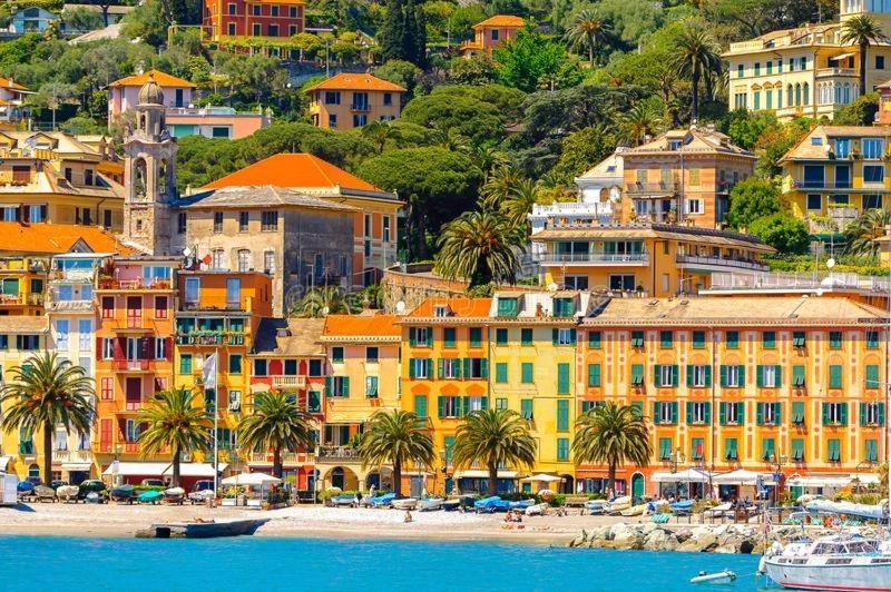 un gruppo di edifici su una collina vicino a una spiaggia di Casa Dany, luminoso trilocale con grande terrazza e box auto a Santa Margherita Ligure