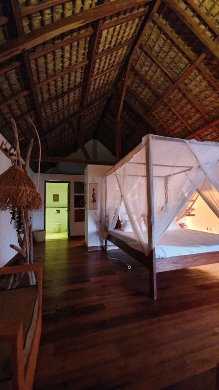 a room with a bed and a wooden floor at LE TRANSAT in Ambatoloaka