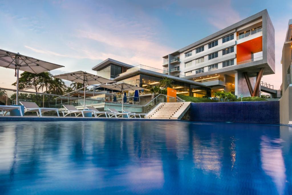 a hotel with a swimming pool in front of a building at Acantilados in La Libertad