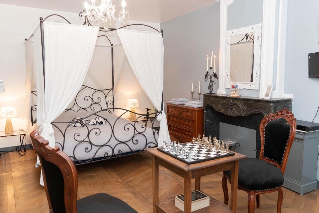 a bedroom with a bed and a table and chairs at La Fée Maison in Châtel-sur-Moselle