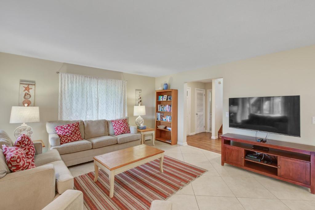 a living room with a couch and a flat screen tv at Carolina Boulevard 128 in Isle of Palms