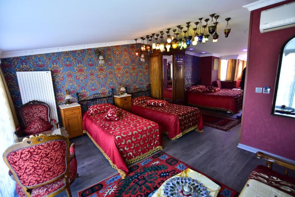 a room with two beds and two chairs in a room at Kybele Hotel in Istanbul