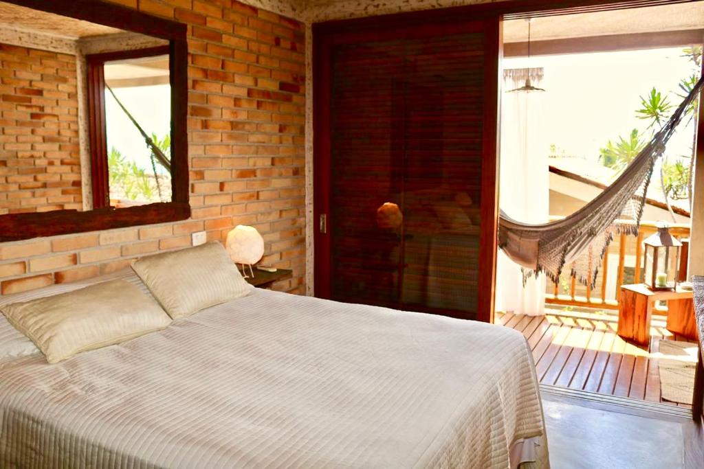 1 dormitorio con 1 cama y 1 hamaca en Villa La Dolce Vita, en Ilhabela