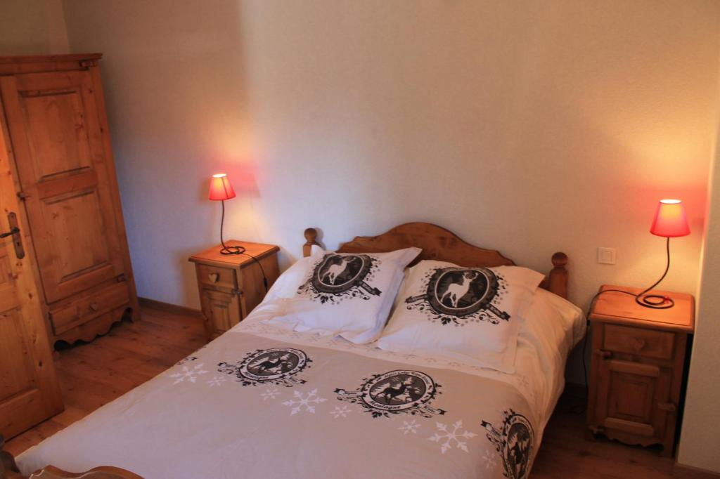 a bedroom with a bed with two night stands and two lamps at La Ferme de Sous-Lachat in Samoëns