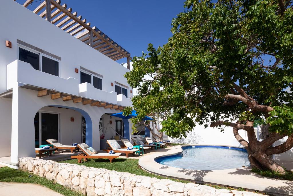 a villa with a swimming pool and a tree at Casa Sienna Lia Spacious House in Isla Mujeres