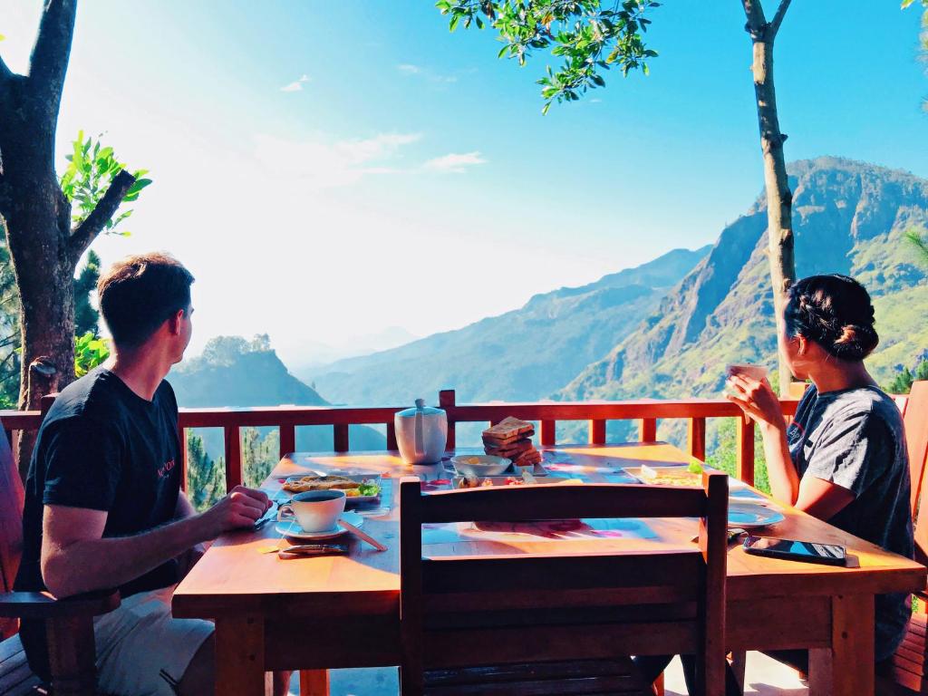 a man and a woman sitting at a wooden table at Inspira ella in Ella