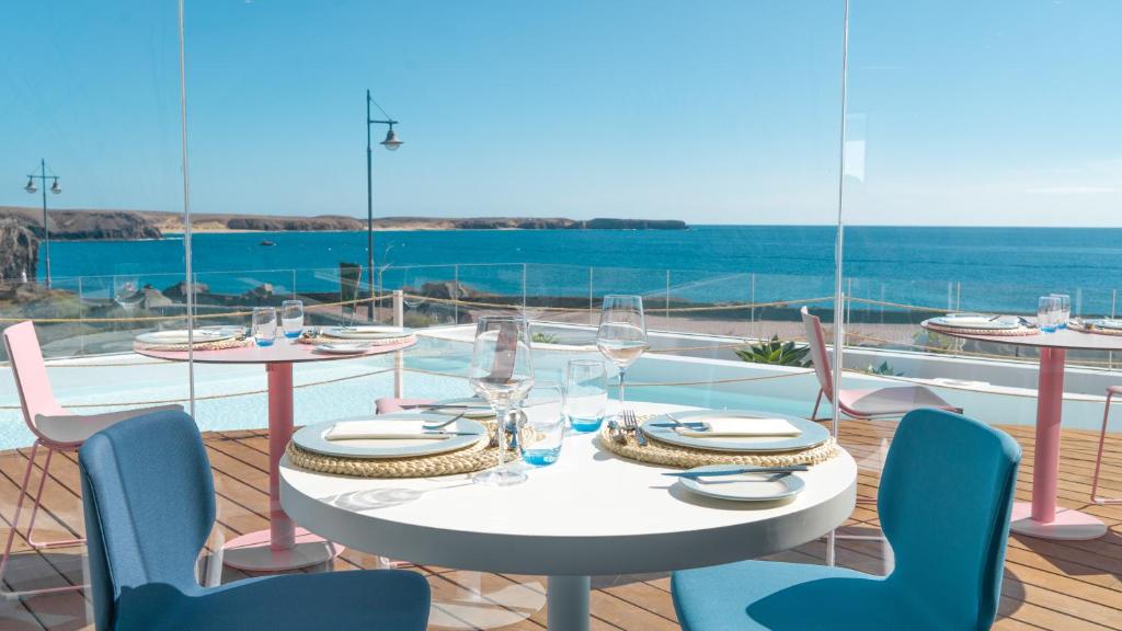 a table and chairs on a balcony with a view of the ocean at CalaLanzarote Suites Hotel - Adults Only in Playa Blanca