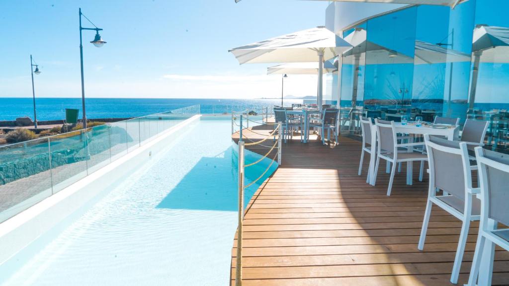 a restaurant with a view of the ocean at CalaLanzarote Suites Hotel - Adults Only in Playa Blanca