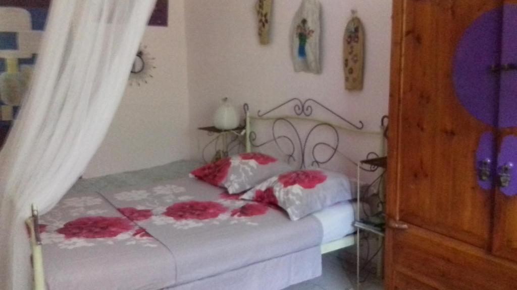 een slaapkamer met een bed met roze bloemen erop bij chez annick et jacques in Vieux Bourg