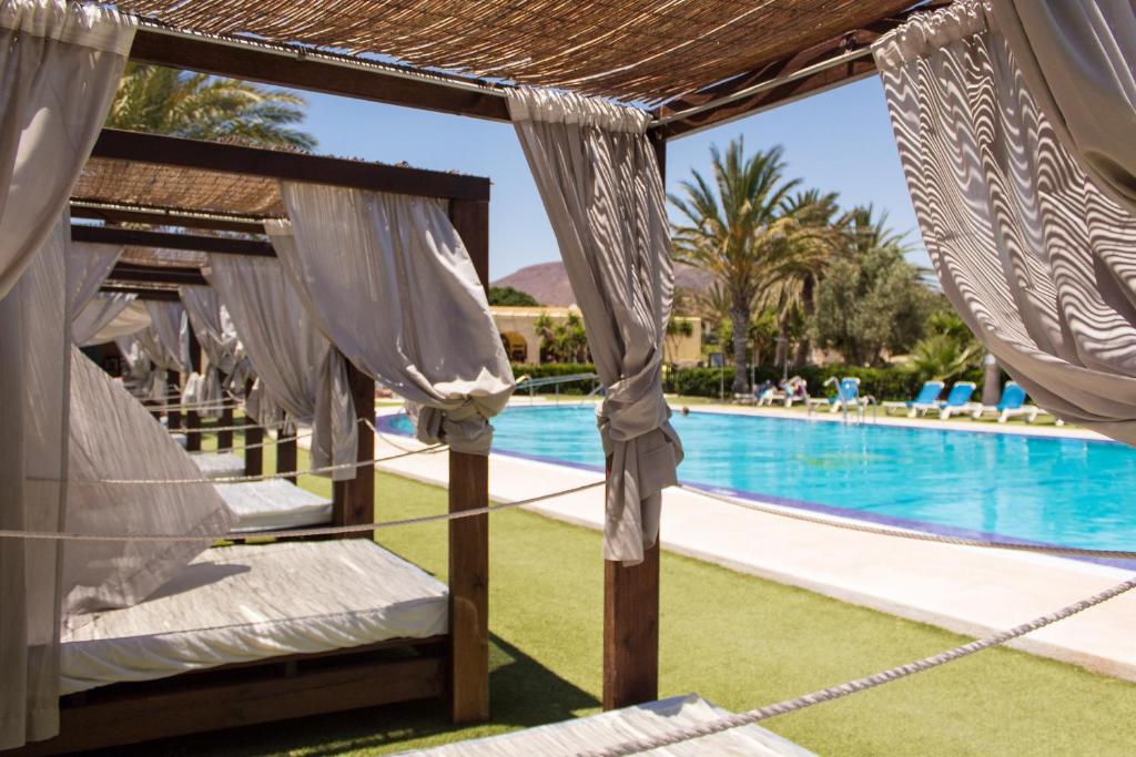 uma rede de descanso à beira da piscina num resort em Complejo Turístico Los Escullos San Jose em Los Escullos